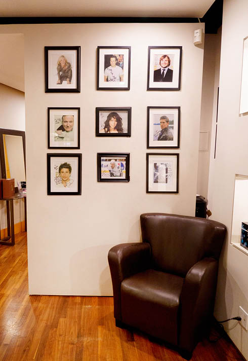 Spa location; wall with framed photos of employees, cozy brown chair