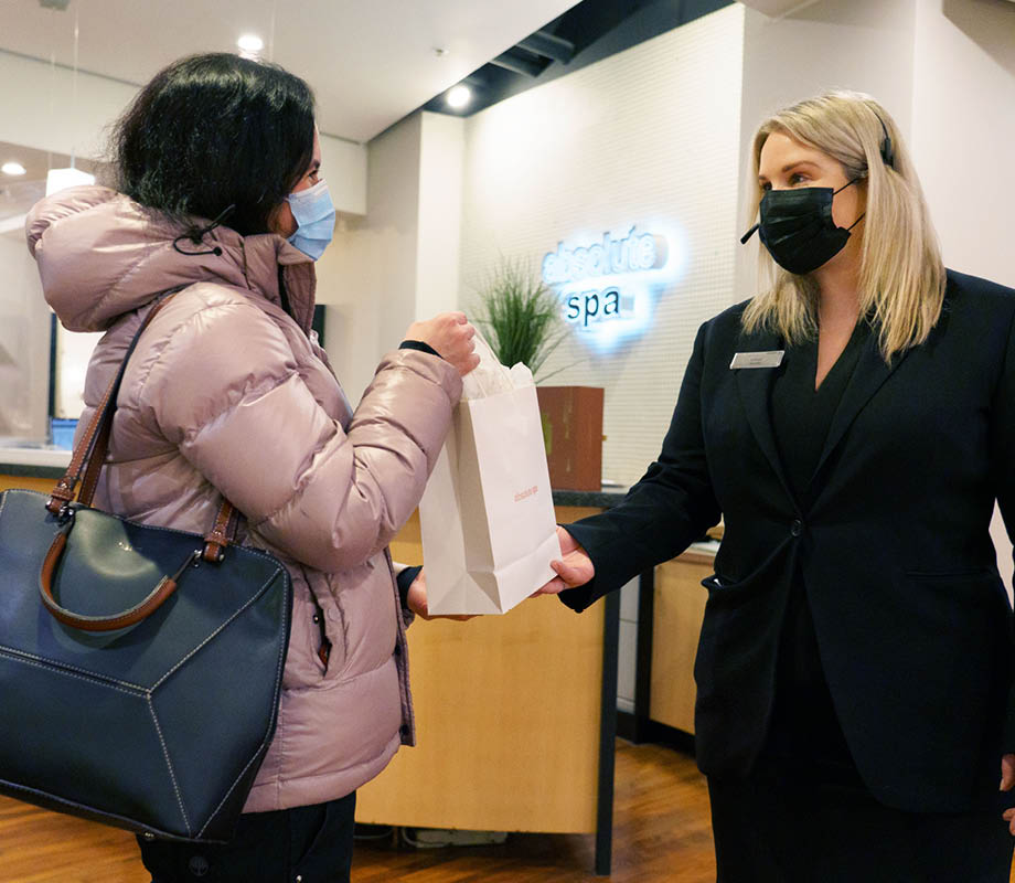 Jill Bryan hands client her purchase at the front end of the spa