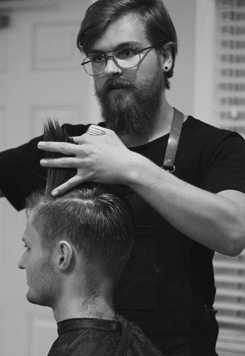 barber Cody Dunbar working on a client's hair at Bourbon Barbershop in Saskatchewan