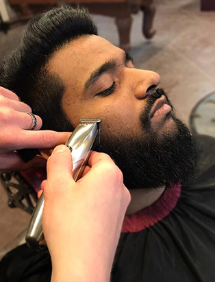 cody dunbar blanche macdonald graduate shaving a client's beard