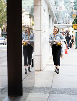 Blanche grad Emily Buhr walking in front of Chanel Store