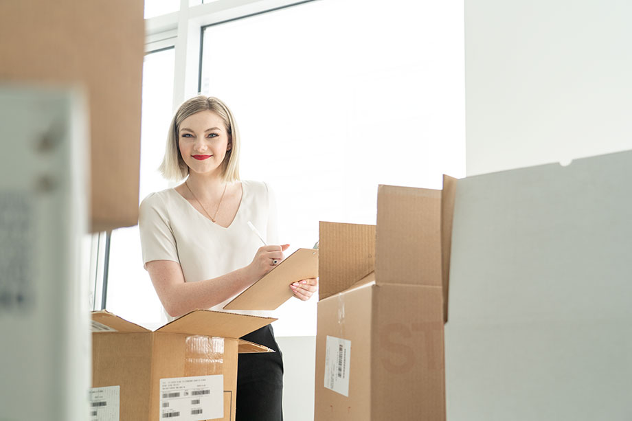 cheerful Emily checking boxes of inventory