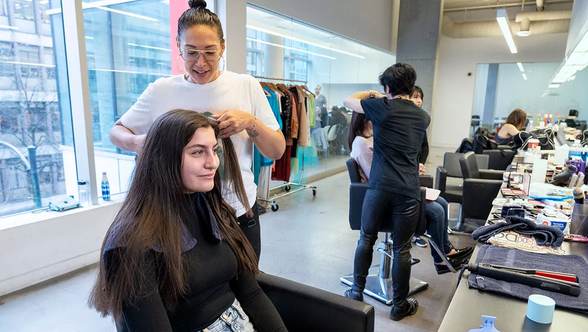 Blanche instructors styling hair and doing makeup