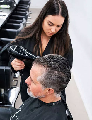 Sandra Perovic using blow dryer on men's hair client