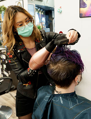 Kimiko Watanabe blowdries her client's hair in the salon chair