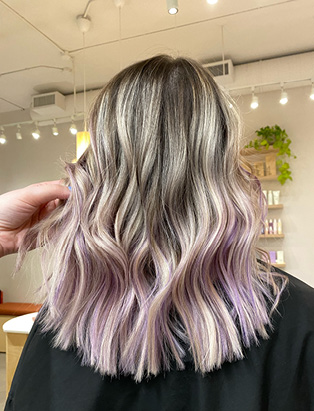 a women wearing an ombre blonde to purple hairstyle, with a loose waves. styled by Kevin Murphy Gold Key Colour Educator Kalli Wyssen