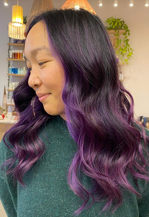 an lady with long length violet purple highlights and dark hair, wearing a large voluminous curls coloured by Kevin Murphy Colour Educator Kalli Wyssen