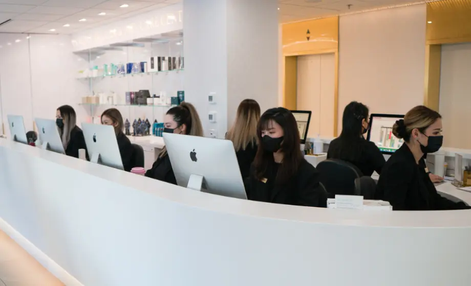 Image of beauty consultant and staff from Vancouver Laser and Skin Care Centre, sitting behind iMacs.