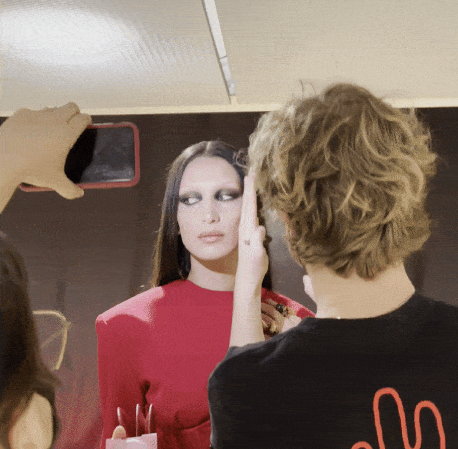 Runway Hair Stylist Sam Groeneveld spraying hair spray for Bella Hadid in Versace backstage FW 22-23