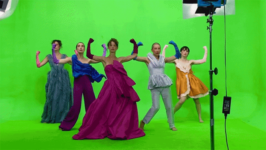 5 models standing in front of a green screen, filming for a music video