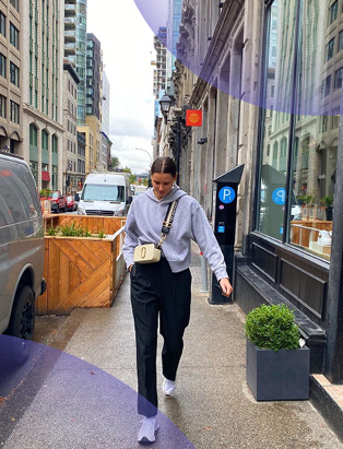 Selfie of Anonda Hoppner, ALDO's Associate Buyer, walking down the street wearing Marc Jacobs snapshot bag in white