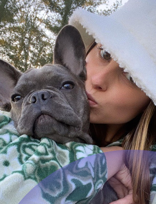 Selfie of Anonda Hoppner, ALDO's Associate Buyer, with her puppy, wearing a white fluffy bucket hat