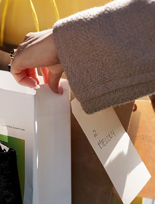 Kimberly Schmalz putting a note on Aritiza shopping bag for personal styling.