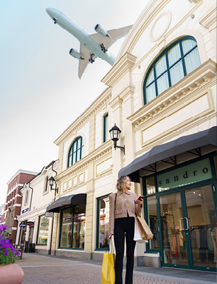 Fashion Buyer, Kimberly Schmalz walking at the McArthurGlen Designer Outlet with shopping bags.