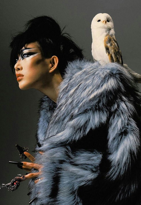 A white owl standing on Sora Choi's shoulder, shot by Zhong Lin, makeup by Jenna Kuchera, First Assistant for Pat McGrath.  