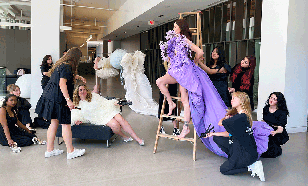 Fashion Marketing students sitting on a wooden ladder at a fashion photoshoot