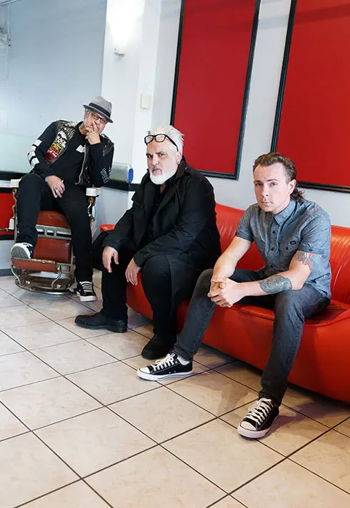 Ash sitting with his friend on a red couch