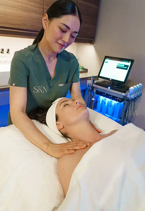 Laser esthetics technician Jackie is performing massages on a female client covered with white towels