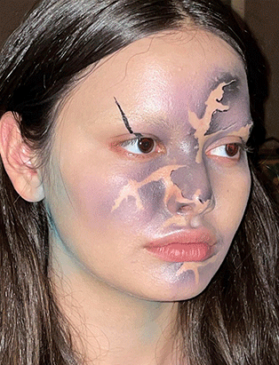 A female model with purple extoic makeup, created by Carole Methot