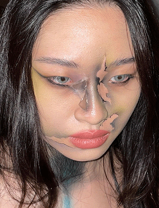 A female model with green extoic makeup, created by Carole Methot