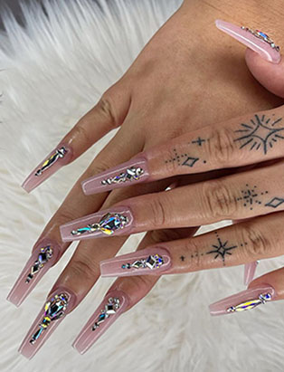 full shot of a nude coffins long nail design with jewelry designs  