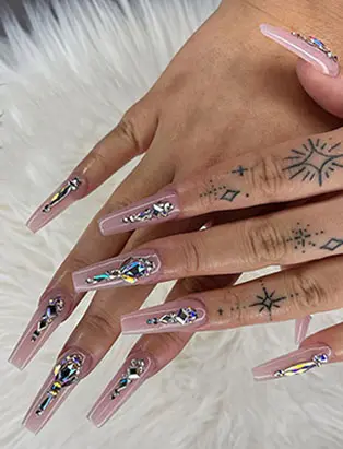 full shot of a nude coffins long nail design with jewelry designs