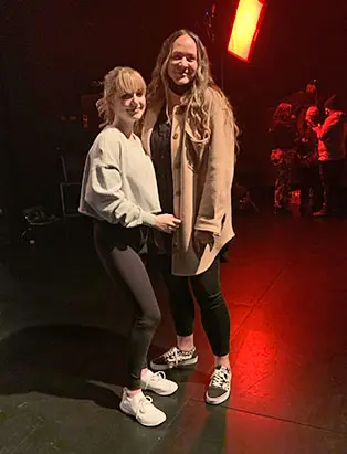 Kara Alaric with actress McKenna Grace in a dark room with red lightings