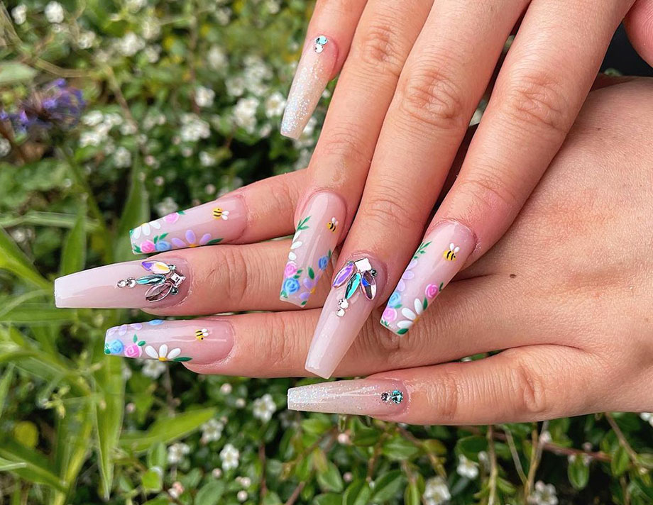 pink coffin nail design with floral prints and jewelry, created by nail tech Hailey Bornais
