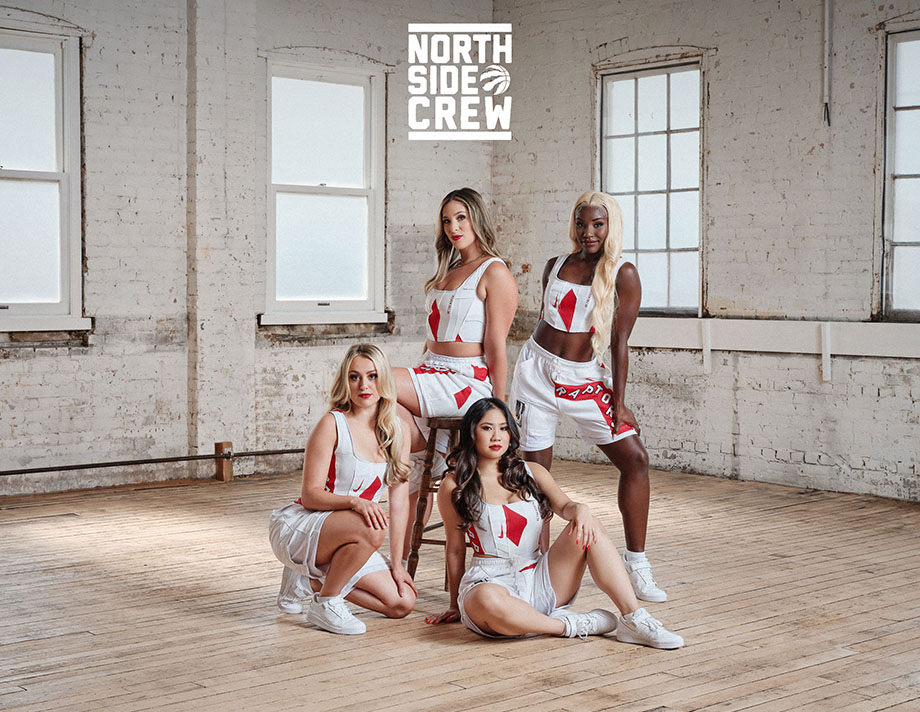 a group of 4 female cheerleaders from North Side crew posing in a white room with wooden floorings