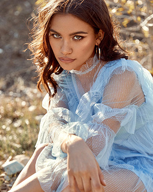 A female model wearing a light blue tulle dress.