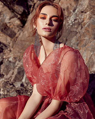 A model wearing light red eyeshadow in a light red mesh puffy dress.