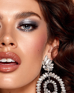A female model wearing silver eyeshadows with a silver rhinestone  earring; makeup designed by Bridal Hair and Makeup Artist Tanin Nicole