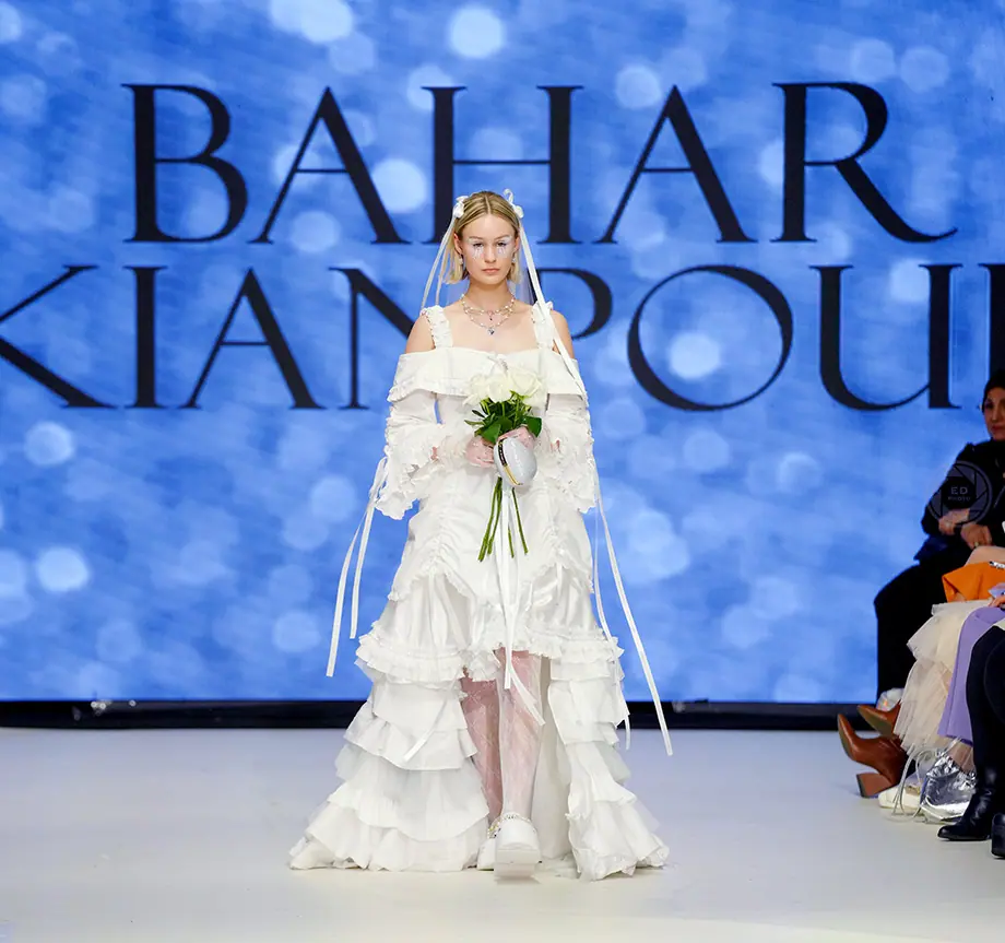A Caucasian female model wearing white dress designed by Bahar Kianpour at Vancouver Fashion Week 2024